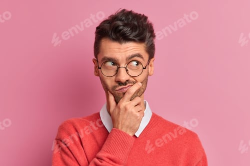Preview: Handsome Thoughtful Man Holds Chin And Looks Doubtful Away Purses Lips Makes Planning Tries To