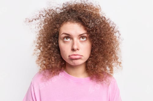 Preview: Studio Shot Of Upset European Woman Purses Lower Lip Looks Sadly Above Being Disappointed By