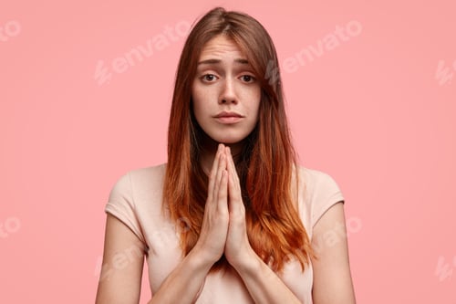 Preview: Freckled Young Female With Pleading Expression, Keeps Palms Pressed Together, Asks For Forgiveness