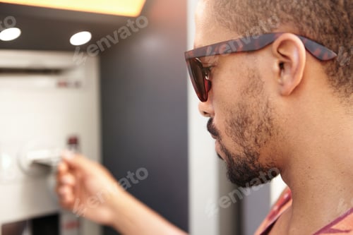 Preview: Profile Headshot Of Young Handsome Serious And Concentrated African Man In Trendy Sunglasses Trying