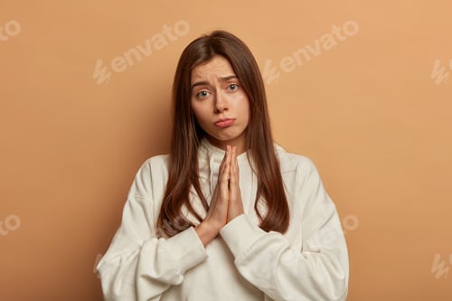 Preview: Please, I Beg You! Gloomy Dissatisfied Woman Keeps Palms In Prayer Gesture, Feels Sorry For Making