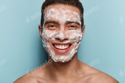 Preview: Skincare And Morning Routine Concept. Positive Man With Soap Scrub On Face, Enjoys Relaxing Time