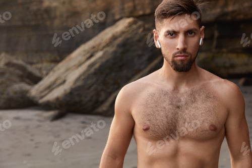 Preview: Outdoor View Of Male Athlete With Serious Facial Expression, Poses Naked On Seaside, Has Good