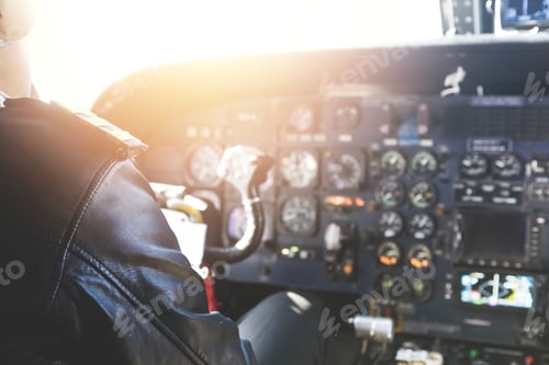 Preview: Rear View Of Adult Male Pilot Wearing Headset And Black Leather Jacket Flying Helicopter On Sunny