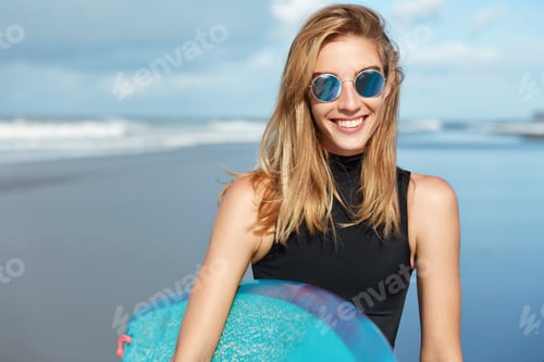 Preview: View Of Pleasant Looking Blonde Woman In Sunglasses, Relaxes On Seashore, Involved In Active Water