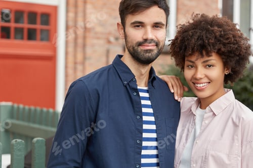 Preview: Outdoor Shot Of Pleasant Looking Smiling Dark Skinned Girl Leans At Shoulder Of Her Cauasian