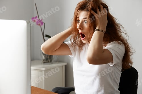 Preview: Pretty Student Girl Having Trouble With Her Laptop, Looking In Panic At The Screen, Holding Her