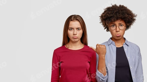 Preview: Horizontal Shot Of Offended Diverse Women Purse Lips In Dissatisfaction, Being Angry With Each