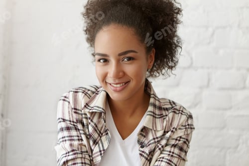 Preview: Portrait Of Positive Charming Young Dark-Skinned Woman With Afro Hairstyle Looking And Smiling At