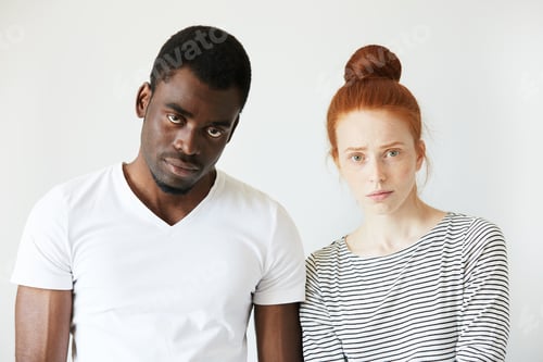 Preview: Portrait Of Young Caucasian Female With Red Hair, Angry And Disappointed With Her African