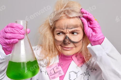 Preview: Scientific Discovery And Chemisty Concept. Serious Female Chemist Looks Attentively At Beaker With