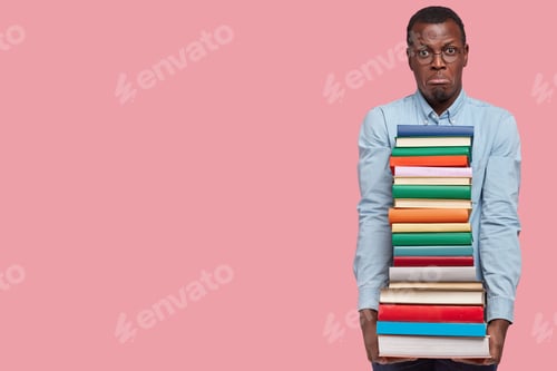 Preview: Photo Of Dissatisfied Young Black Man Holds Pile Of Textbooks, Displeased With Studying, Purses