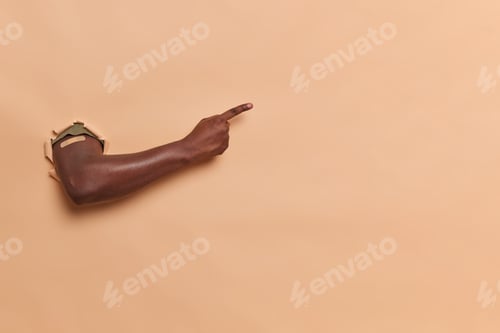 Preview: Unknown Dark Skinned Man Shows Arm Through Paper Hole Indicates Index Finger Away Wears Band Aid