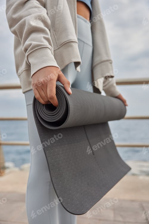 Preview: Woman Holding Rolled Yoga Mat Near the Ocean