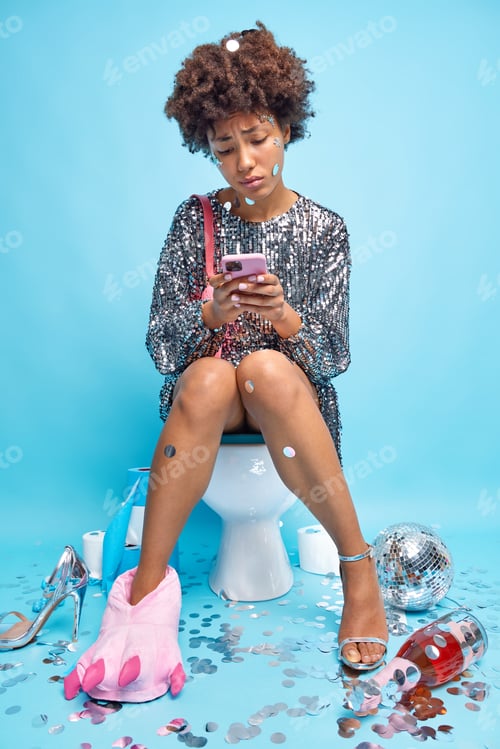 Vista previa: Upset Curly Haired Young Woman Dressed In Fashionable Shiny Dress Surrounded By Party Attributes