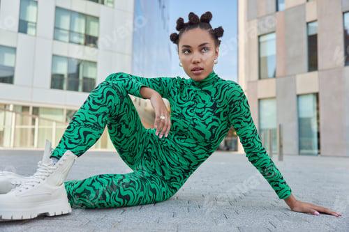 Preview: Thoughtful Pretty Woman With Trendy Hairstyle Wears Green Bodysuit And White Boots Poses In Urban
