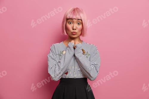 Preview: Cute Asian Teenage Girl With Surprised Face Expression Keeps Lips Rounded Hands Together Shocked To