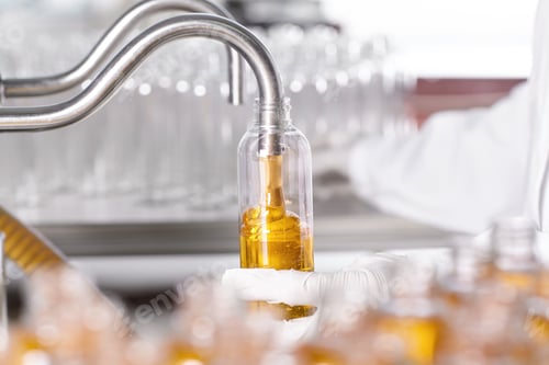 Preview: Young Scientist Wearing White Gown And Gloves Standing In Modern Laboratory Tube Filling It With