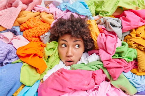 Preview: Woman Head Sticking Out Through Different Multicolored Clothes Looks Away With Stunned Expression