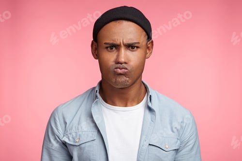 Preview: Grumpy Dissatisfied Mixed Race Male Pouts Lips, Being Angry With Someone Or Offended, Has Unhappy