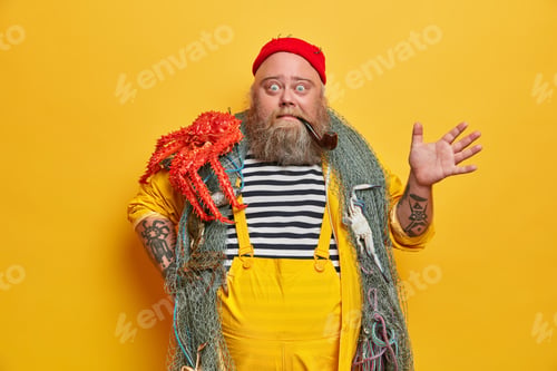Preview: Surprised Emotional Seafarer Smokes Pipe And Raised Hand, Stares Bugged Eyes At Camera. Bearded
