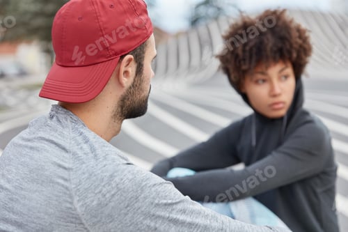 Preview: Stylish Female And Male Hipsters Sit On Road, Have Street Style, Dressed In Sweatshirt, Have