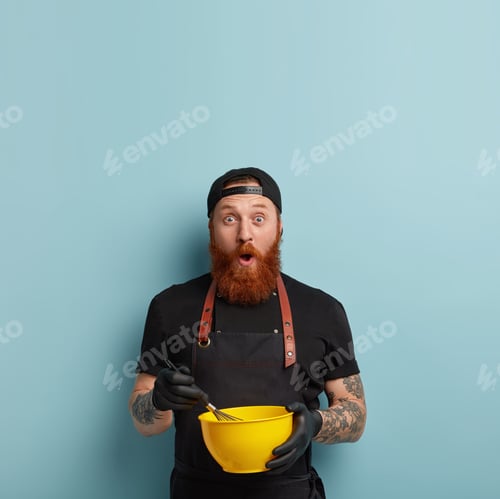 Preview: Vertical Shot Of Stupefied Emotive Hipster Gazes With Surprisement, Holds Bowl And Whisk, Whipps