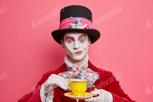 Preview: Horizontal Shot Of Serious Male Hatter Poses With Cup Of Tea Wears Hat Has Manners Of Aristocratic