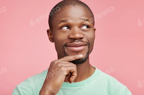 Preview: Smiling Happy Dark Skinned Male Looks Up, Has Thoughtful Expression, Dreams About Something