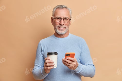 Preview: Indoor Shot Of Handsome Bearded Mature Man Has Free Time After Work Checks Social Networks On