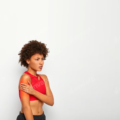 Preview: Vertical Shot Of Displeased African American Woman Suffers From Pain In Shoulder, Has Bare Belly