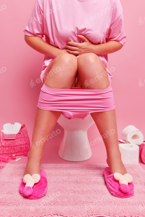 Preview: Cropped Image Of Unknown Woman Feels Stomachache Has Period Cramps Sits On Toilet Bowl Wears T