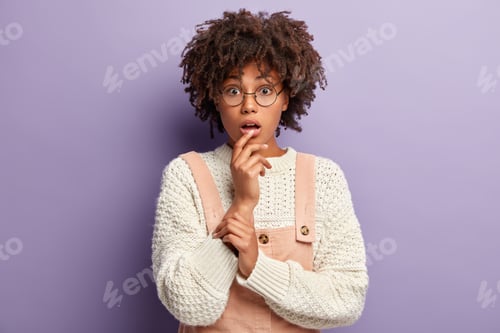 Vista previa: Headshot Of Impressed Curious Woman Has Bewildered Look, Keeps Hands Partly Crossed, Mouth Opened