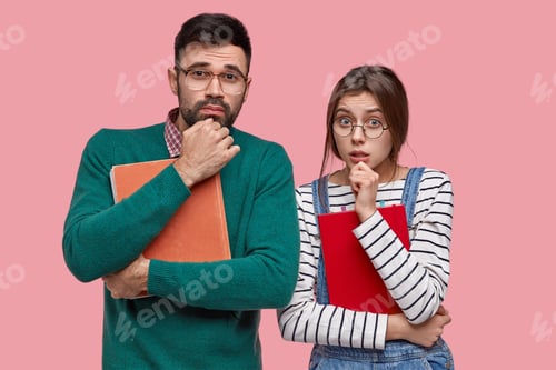 Preview: Photo Of Two Frustrated Young Woman And Man Hold Chins, Have Attentive Look At Camera, Carry