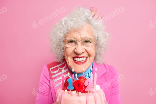 Preview: Portrait Of Lovely Grandmother With Makeup Celebrates 102Nd Birthday Blows Candles On Bday Cake