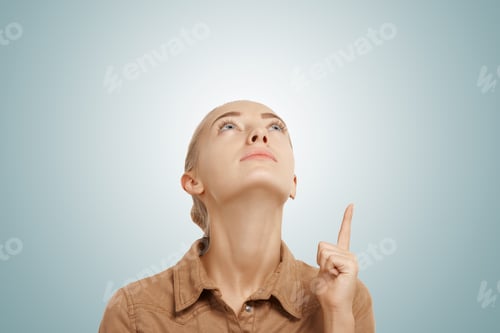 Preview: Close Up View Of Young Beautiful Caucasian Blonde Woman Pointing And Looking Up At Copy Space For