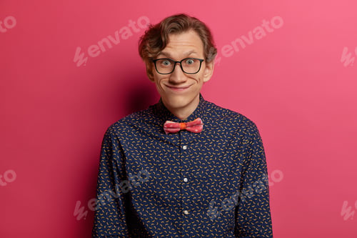 Preview: Funny Young Man Gazes With Comic Expression At Camera, Wears Optical Glasses And Stylish Shirt