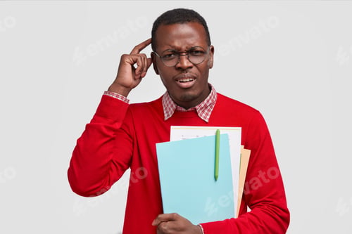Preview: Dissatisfied Pupil Scratches Head, Frowns Face, Dressed In Casual Red Jumper, Carries Papers With