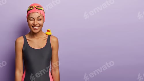 Preview: Relaxed Happy Dark Skinned Woman Blinks Eye, Has Fun At Beach During Summer Time, Enjoys Vacation