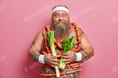 Preview: Bearded Plump European Man Chooses Between Healthy Green Vegetbles And Sausages, Consults