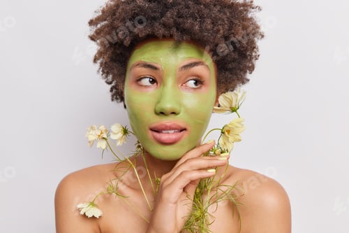Preview: Spa Beauty Treatments And Wellbeing Concept. Afro American Woman Applies Natural Green Mask Made Of