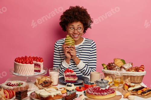 Preview: Cheerful Curly Haired Female Holds Tasty Croissant, Looks Aside, Cannot Wait To Eat All Desserts On