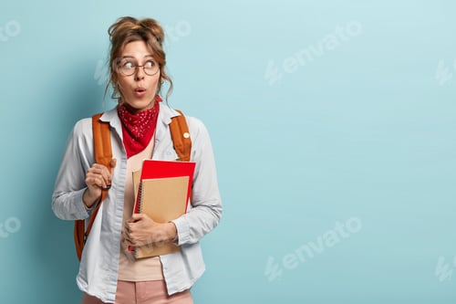 Preview: Surprised Schoolgirl With Backpack, Holds Spiral Notepad, Red Textbook, Shocked To Have Session