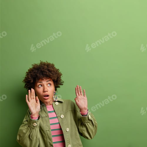 Preview: Scared Beautiful Curly Haired Afro American Keeps Her Arms Up Like Something Falling Above Dressed