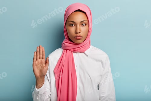Preview: Slow Down And Stop. Serious Dark Skinned Arabic Woman Shows Refusal Gesture, Raises Palm Towards