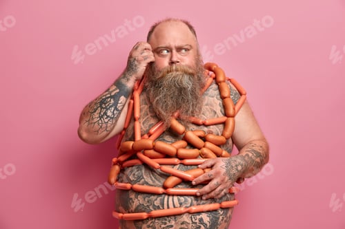 Preview: Thick Bearded Man Wrapped In Sausages, Scratches Head And Looks Away Thoughtfully, Obsessed With
