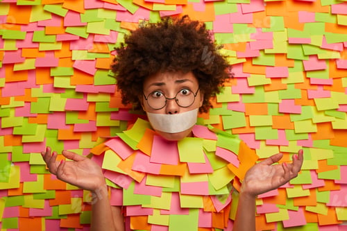 Preview: Confused Clueless Afro American Woman With Taped Mouth Spreads Palms With Hesitation, Sees No Way
