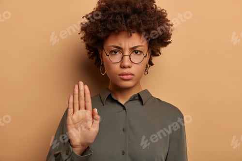 Preview: Bossy Serious Looking Woman Looks Strictly At Camera, Extends Palm, Expresses Taboo Or Prohibition