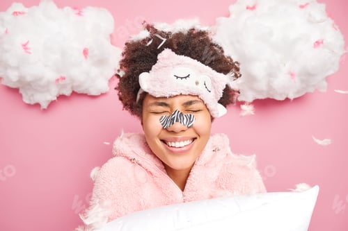 Vista previa: Positive Young Afro American Woman Smiles Toothily Keeps Eyes Closed Enjoys Morning Time After Good