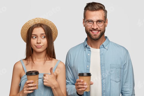 Preview: Smiling Couple Holding Coffee Cups in Studio Setting